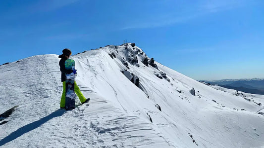 Snowboarder overlooking a snowy mountain range