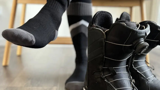 Snowboarder putting on ski socks