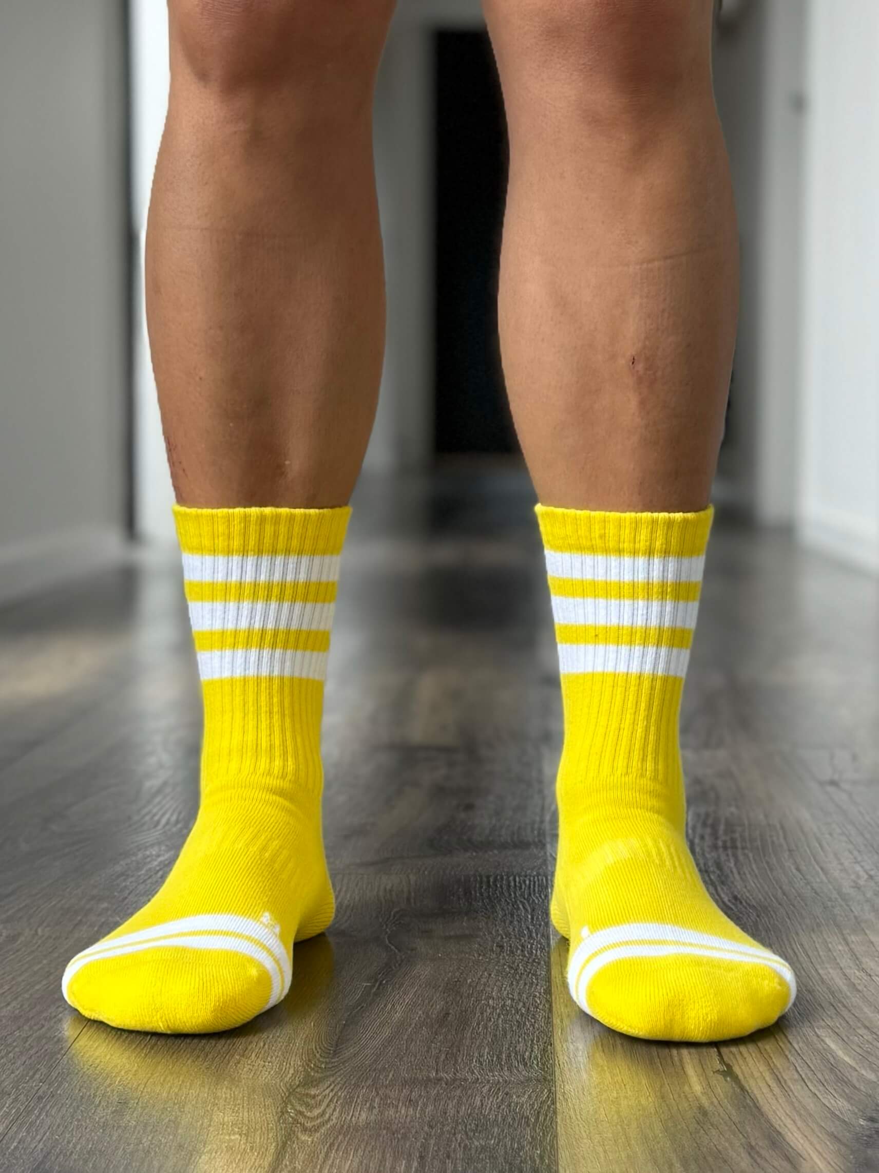 Organic cotton crew sports sock in bright yellow with white stripes.